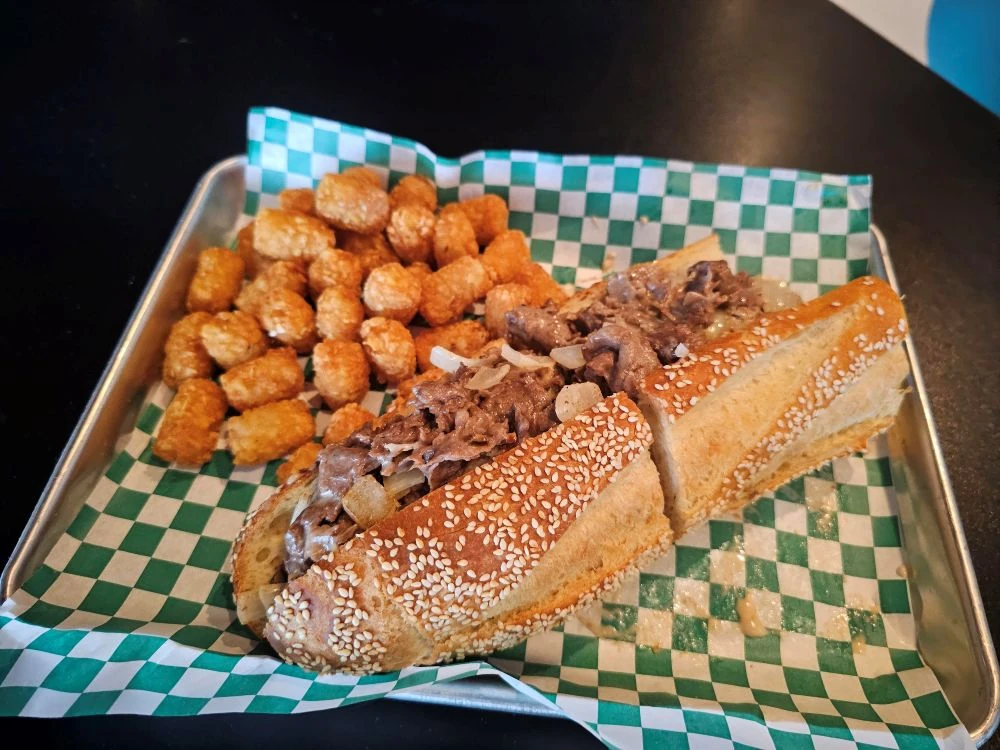 Ribeye cheesesteak on Madison’s house-baked Italian seeded roll, served with tots